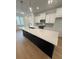Open kitchen features white cabinets, stainless steel appliances, island with countertop, and pendant lighting at 1932 Appian Aly, Kennesaw, GA 30144