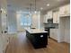 Kitchen with black island, quartz countertops, modern pendant lights and stainless steel appliances at 1932 Appian Aly, Kennesaw, GA 30144