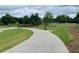 A concrete pathway cuts through a green park with trees, a bridge, and decorative lighting at 1932 Appian Aly, Kennesaw, GA 30144