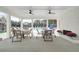 An outside eating area by the pool with multiple tables and chairs underneath a ceiling with fans at 1932 Appian Aly, Kennesaw, GA 30144