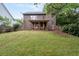 Exterior of house featuring a large grassy backyard, mature trees, and a covered porch at 238 Ivy Glen Cir, Avondale Estates, GA 30002