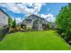 Expansive backyard with lush green grass, manicured landscaping, and a black iron fence at 3755 Valleyway Rd, Cumming, GA 30040