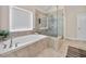 Bright bathroom with a large soaking tub, glass shower enclosure, and modern fixtures at 3755 Valleyway Rd, Cumming, GA 30040