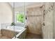 Luxurious bathroom featuring a soaking tub, tiled walk-in shower, and natural light from the window at 3755 Valleyway Rd, Cumming, GA 30040