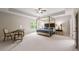 Large main bedroom with a four-poster bed, tray ceiling, and sitting area at 3755 Valleyway Rd, Cumming, GA 30040