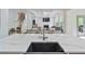 Kitchen island with dark sink and eat-in seating looks into the living room at 3755 Valleyway Rd, Cumming, GA 30040