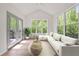 Bright sunroom with ample windows, a comfortable seating area, and access to an outdoor deck at 3755 Valleyway Rd, Cumming, GA 30040