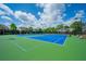 Well-maintained tennis courts with bright blue playing surface and green surround on a sunny day at 3755 Valleyway Rd, Cumming, GA 30040
