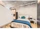 Charming bedroom featuring a cozy bed with a blue blanket, wooden floor, and stylish, exposed concrete walls at 400 W Peachtree Nw St # 2614, Atlanta, GA 30308