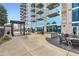 Condo patio featuring an arbor, tables and chairs, and reflecting the building's glass facade at 400 W Peachtree Nw St # 2614, Atlanta, GA 30308