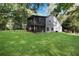 Large backyard with a lush lawn, mature trees, and a screened-in porch at 2100 Stone Hollow Ct, Marietta, GA 30062