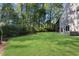 Green backyard with lush lawn, mature trees, and the home's rear facade at 2100 Stone Hollow Ct, Marietta, GA 30062