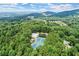Gorgeous aerial view of the community featuring the pool and tennis courts surrounded by lush trees and distant mountains at 4295 Parish Trce, Marietta, GA 30066