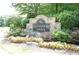 The community entrance featuring a stone sign surrounded by beautiful landscaping and flowers at 4295 Parish Trce, Marietta, GA 30066