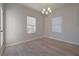 Large, open dining room with hardwood floors, a modern chandelier, and two large windows at 502 Charleston Pl, Villa Rica, GA 30180