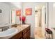 Well-lit bathroom with double sinks, wood cabinets, and a separate toilet and shower space at 3140 Willow Park Dr, Dacula, GA 30019