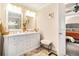 Bathroom featuring a double sink vanity, tiled floor, a framed mirror, and a view into the main bedroom at 3140 Willow Park Dr, Dacula, GA 30019