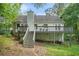 Rear view of the house with a large deck, set in a serene backyard with mature trees at 3140 Willow Park Dr, Dacula, GA 30019