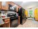 Bright kitchen featuring dark appliances, plenty of storage, and breakfast nook area at 3140 Willow Park Dr, Dacula, GA 30019