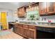 Traditional kitchen featuring wood cabinets, tiled floor, black dishwasher, and a window over the sink at 3140 Willow Park Dr, Dacula, GA 30019