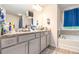 Bathroom with granite countertops, grey cabinets, and tub at 328 Orchid Dr, Mcdonough, GA 30252