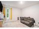 Cozy bedroom featuring soft carpet, a large window with natural light, and a comfortable gray sofa at 328 Orchid Dr, Mcdonough, GA 30252