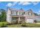 Traditional two-story home with brick accents, a covered porch, and a two-car garage at 328 Orchid Dr, Mcdonough, GA 30252