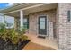 Close-up of a charming front porch with brick columns, a welcome sign, and lush landscaping at 328 Orchid Dr, Mcdonough, GA 30252