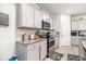 Well-lit kitchen features granite countertops, light grey cabinets and stainless steel appliances at 328 Orchid Dr, Mcdonough, GA 30252