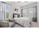 Bright bedroom with neutral décor, three windows, and a cozy gray couch at 613 Stickley Oak Way, Woodstock, GA 30189