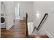 Hallway with wood floors leading past the laundry room and stairs to the second floor at 613 Stickley Oak Way, Woodstock, GA 30189