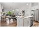 Open concept living and kitchen area with stainless steel appliances and natural light from the large windows and doors at 613 Stickley Oak Way, Woodstock, GA 30189