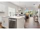 Kitchen with stainless steel appliances, white cabinets, quartz countertop and a view of the living area at 613 Stickley Oak Way, Woodstock, GA 30189