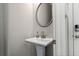 Chic powder room with a pedestal sink, brushed nickel fixtures, and convenient access to the main living areas at 613 Stickley Oak Way, Woodstock, GA 30189