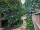 A charming stone path leads to a backyard with mature trees and a relaxing seating area at 215 Haleys Ct, Woodstock, GA 30188