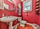 Charming half-bathroom featuring a pedestal sink and vibrant red walls at 215 Haleys Ct, Woodstock, GA 30188