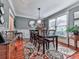 Formal dining room with hardwood floors, elegant wainscoting, a stylish chandelier, and a large window at 215 Haleys Ct, Woodstock, GA 30188