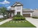 Charming two-story home featuring a welcoming front porch, well-manicured lawn, and an attached two-car garage at 215 Haleys Ct, Woodstock, GA 30188