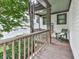 Cozy covered porch with wooden flooring, railings, and a comfortable chair perfect for relaxation and enjoying the outdoors at 215 Haleys Ct, Woodstock, GA 30188