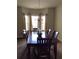 Elegant dining room with a wooden table, chandelier, and large windows with sheer curtains at 6074 Locklear Way, Douglasville, GA 30134