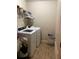Bright laundry area featuring tile flooring, washer, dryer, storage shelf, and natural light at 6074 Locklear Way, Douglasville, GA 30134