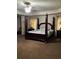 Spacious main bedroom featuring a four-poster bed, ceiling fan, carpet and two bedside tables with lamps at 6074 Locklear Way, Douglasville, GA 30134