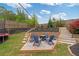 Beautiful backyard with a fire pit area, chairs, a trampoline, and a lush, landscaped garden at 7730 Tiberon Pkwy, Cumming, GA 30028