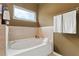 Cozy bathroom showcasing a built-in tub, tile surround, and a bright window at 7730 Tiberon Pkwy, Cumming, GA 30028