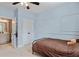 bedroom with light blue walls and carpet, featuring a bed and bathroom doorway at 7730 Tiberon Pkwy, Cumming, GA 30028