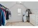 Walk-in closet with sloped ceilings and ample storage space with clothes and a mirror at 7730 Tiberon Pkwy, Cumming, GA 30028