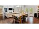 Bright dining room featuring hardwood floors and a rustic wooden table with seating for eight at 7730 Tiberon Pkwy, Cumming, GA 30028