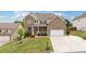 Charming two-story brick home with a well-manicured lawn and inviting front porch at 7730 Tiberon Pkwy, Cumming, GA 30028