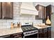 The kitchen has a gas range, subway tile backsplash, granite counters, and dark wood cabinets at 7730 Tiberon Pkwy, Cumming, GA 30028