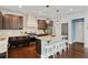 Kitchen boasts a granite island with seating, stainless steel appliances, and hardwood flooring at 7730 Tiberon Pkwy, Cumming, GA 30028